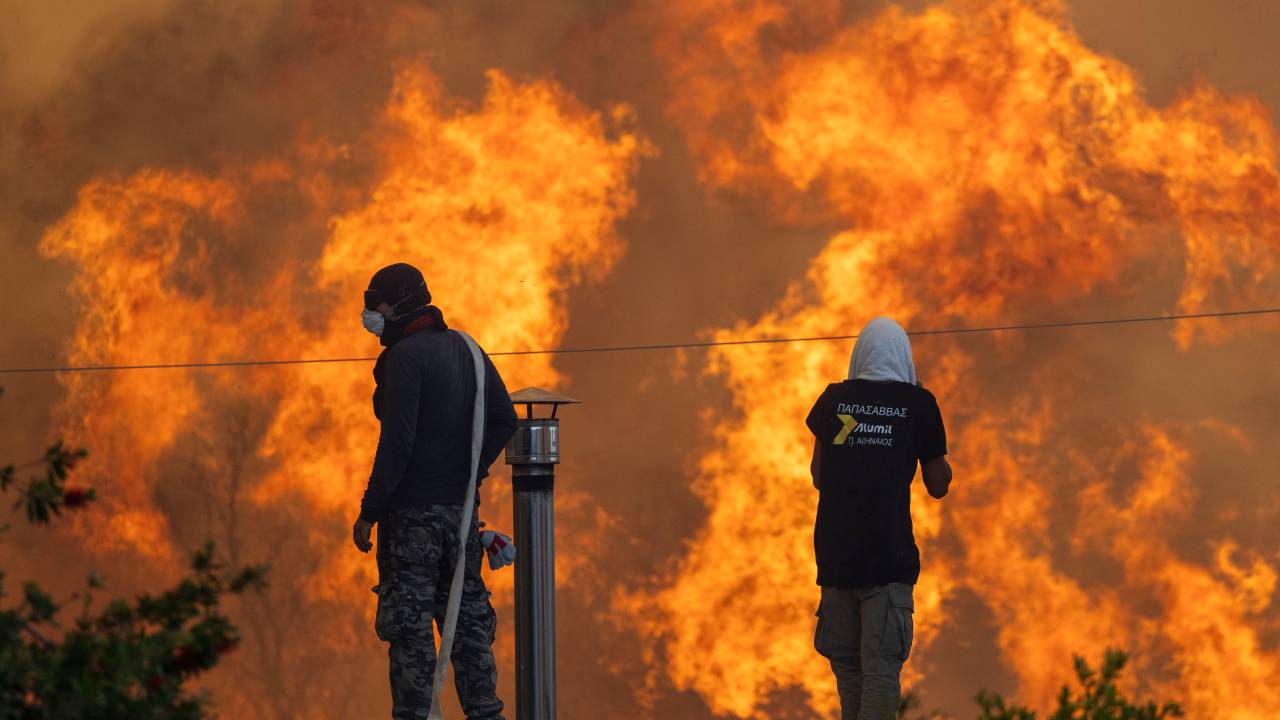 Moradores tentam salvar suas casas com mangueiras de água, na vila de Gennadi, na Grécia. 25/07/2023