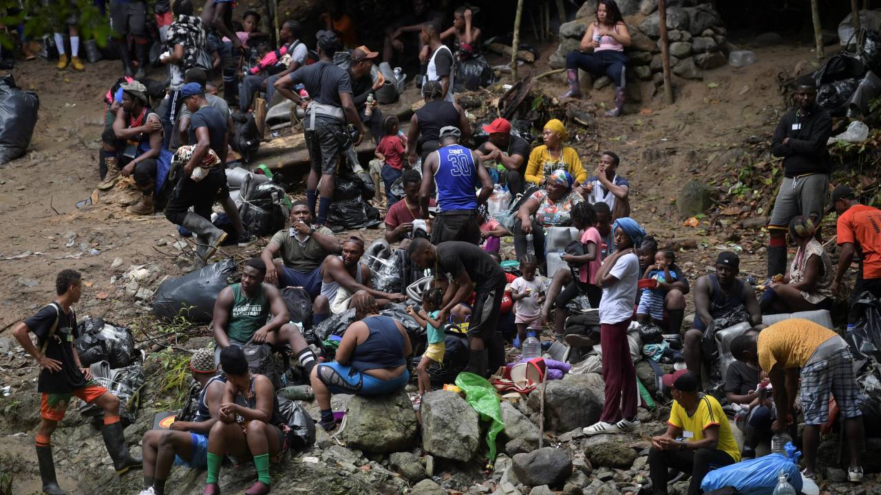 (FILES) Haitian migrants rest as they cross the jungle of the Darien Gap, near Acandi, Choco department, Colombia, heading to Panama, on September 26, 2021, on their way trying to reach the US. Halfway into 2023, nearly a quarter million migrants have crossed the Darien Gap, the dense jungle separating Panama and Colombia, already breaking last year's record, Panama's government said on July 31, 2023. The Darien Gap, 165 miles (265 kilometres) long, has become a corridor from South America for migrants heading to the United States via Central America, despite its dangers. (Photo by Raul ARBOLEDA / AFP)