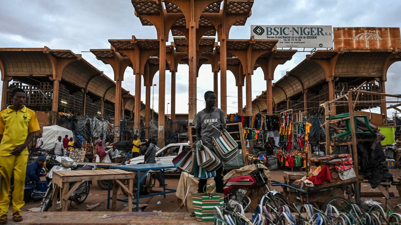 A vendor sells bags outside a market in Niamey on August 14, 2023. (Photo by AFP)