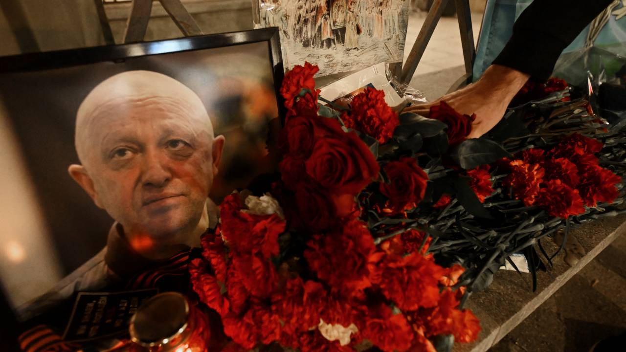 A man lays flowers at the makeshift memorial in honor of Yevgeny Prigozhin and Dmitry Utkin, a shadowy figure who managed Wagner's operations and allegedly served in Russian military intelligence, in Moscow, on August 24, 2023. Russian state-run news agencies on August 23, 2023 said that Yevgeny Prigozhin, the head of the Wagner group that led a mutiny against Russia's army in June, was on the list of passengers of a plane that crashed near the village of Kuzhenkino in the Tver Region. (Photo by NATALIA KOLESNIKOVA / AFP)
