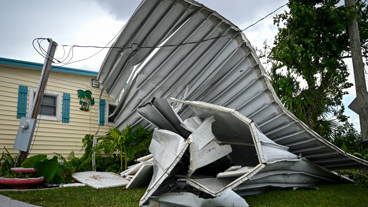 Pieces of fencing torn down by the wind are seen crumbled in a yard in the community of Signal Cove in Hudson, Florida, on August 30, 2023, after Hurricane Idalia made landfall. Idalia slammed into northwest Florida as an "extremely dangerous" Category 3 storm early Wednesday, buffeting coastal communities with cascades of water as officials warned of "catastrophic" flooding in parts of the southern US state. (Photo by Miguel J. Rodriguez Carrillo / AFP)