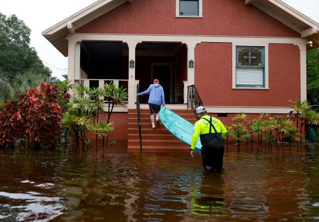Vizinhos se ajudam a carregar um caiaque até a varanda pelas ruas inundadas de Tarpon Springs, Flórida. 31/08/2023 - Vizinhos se ajudam a carregar um caiaque até a varanda pelas ruas inundadas de Tarpon Springs, Flórida. 31/08/2023 -