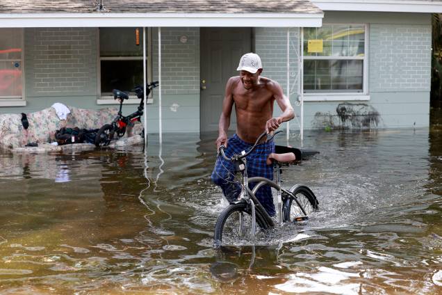 Homem tem dificuldade em caminhar com sua bicicleta, em frente à sua casa inundada devido ao furacão Idalia em Crystal River, na Flórida. 31/08/2023 - Homem tem dificuldade em caminhar com sua bicicleta, em frente à sua casa inundada devido ao furacão Idalia em Crystal River, na Flórida. 31/08/2023 -