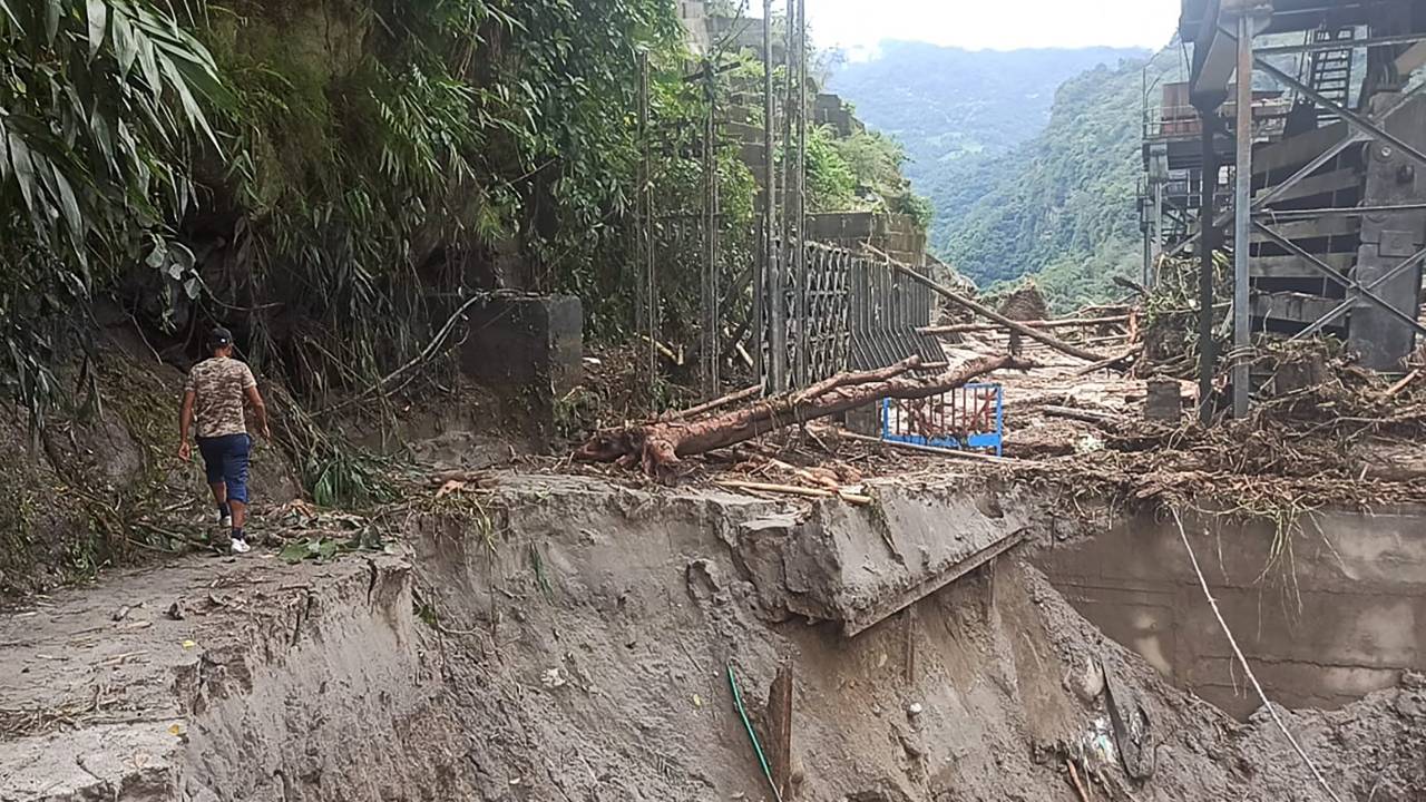 A man walks along a destroyed road near the damaged Teesta V power plant some 6 Km from Singtam in India's Sikkim state on October 5, 2023, a day after a flash flood triggered by a high-altitude glacial lake burst. Indian rescue teams searched on October 5 for 102 people missing after a devastating flash flood triggered by a high-altitude glacial lake burst killed at least 14, officials said. (Photo by Pankaj DHUNGEL / AFP)