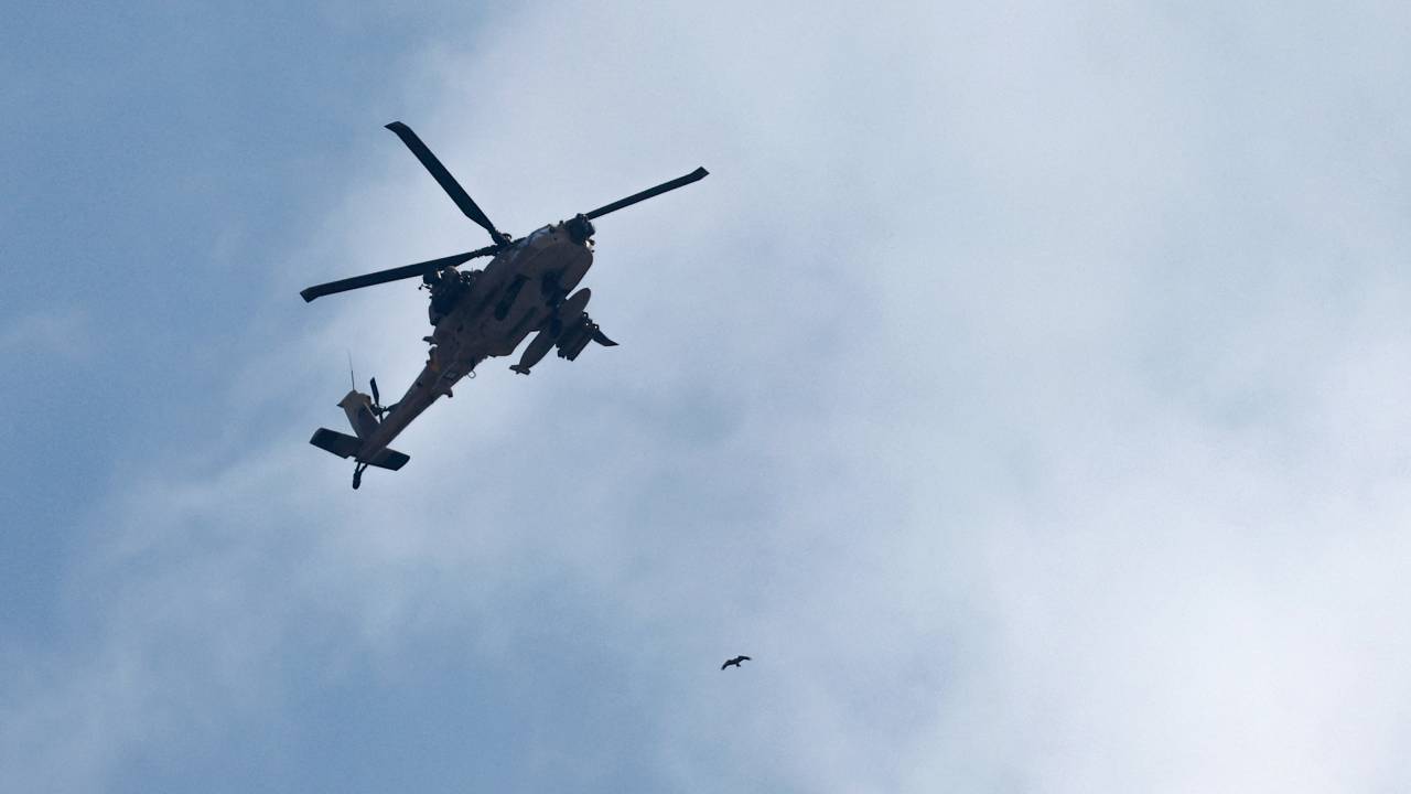 An Israeli helicopter patrols the skies near the border with Gaza in southern Israel on October 10, 2023. Israel pounded Hamas targets in Gaza on October 10 and said the bodies of 1,500 Islamist militants were found in southern towns recaptured by the army in gruelling battles near the Palestinian enclave. (Photo by JACK GUEZ / AFP)