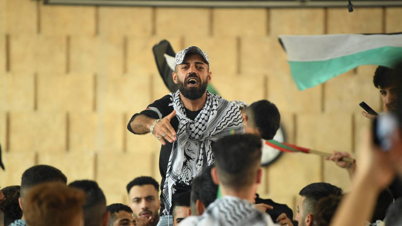 A student from Aleppo University wearing a Palestinian chequerred keffiyeh shouts slogans during a rally in support of the Palestinian cause on campus in the northern Syrian city, on October 11, 2023. The death toll from five days of ferocious fighting between Hamas and Israel rose sharply overnight as Israel kept up its bombardment of Gaza on October 11, after recovering the dead from the last communities near the border where Palestinian militants had been holed up. (Photo by AFP)