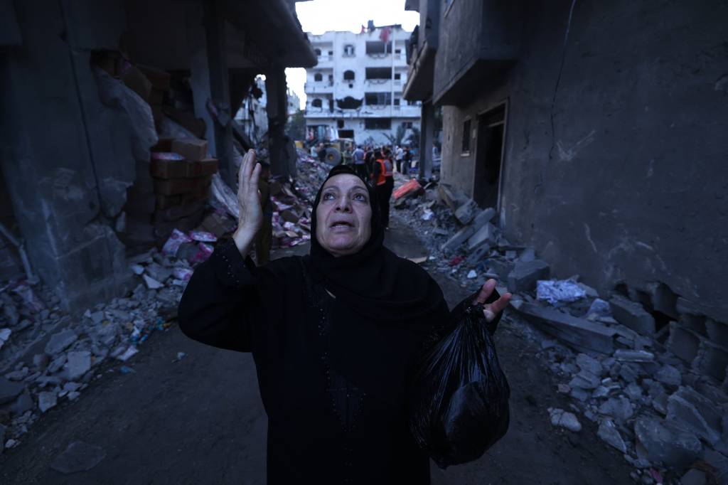 A Palestinian reacts amidst the rubble of a building after an Israeli airstrike on the Rafah refugee camp, in the southern Gaza Strip on October 17, 2023. Relief convoys which have been waiting for days in Egypt were on October 17, headed towards the Rafah border crossing with the besieged Palestinian enclave of Gaza, aid officials said. (Photo by MOHAMMED ABED / AFP)