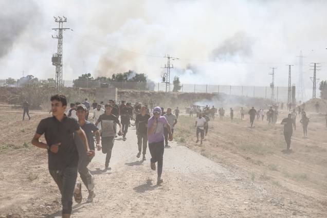 Pessoas correm diante de confrontos entre grupos palestinos e forças de defesa de Israel em Gaza (07/10/2023) Pessoas correm diante de confrontos entre grupos palestinos e forças de defesa de Israel em Gaza (07/10/2023)