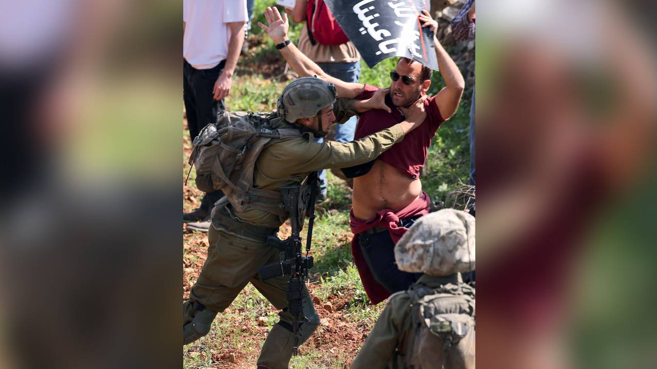 A member of the Israeli security forces scuffles with a protestor as Palestinian and Israeli peace activists demonstrate at the entrance of Huwara in the occupied West Bank, on March 3, 2023, following deadly violence by Israeli settlers. Late on February 26, the Palestinian town of Huwara came under attack by Israeli settlers, hours after two settlers were shot dead as they drove through the northern West Bank town. Credito: Jaafar ASHTIYEH/AFP