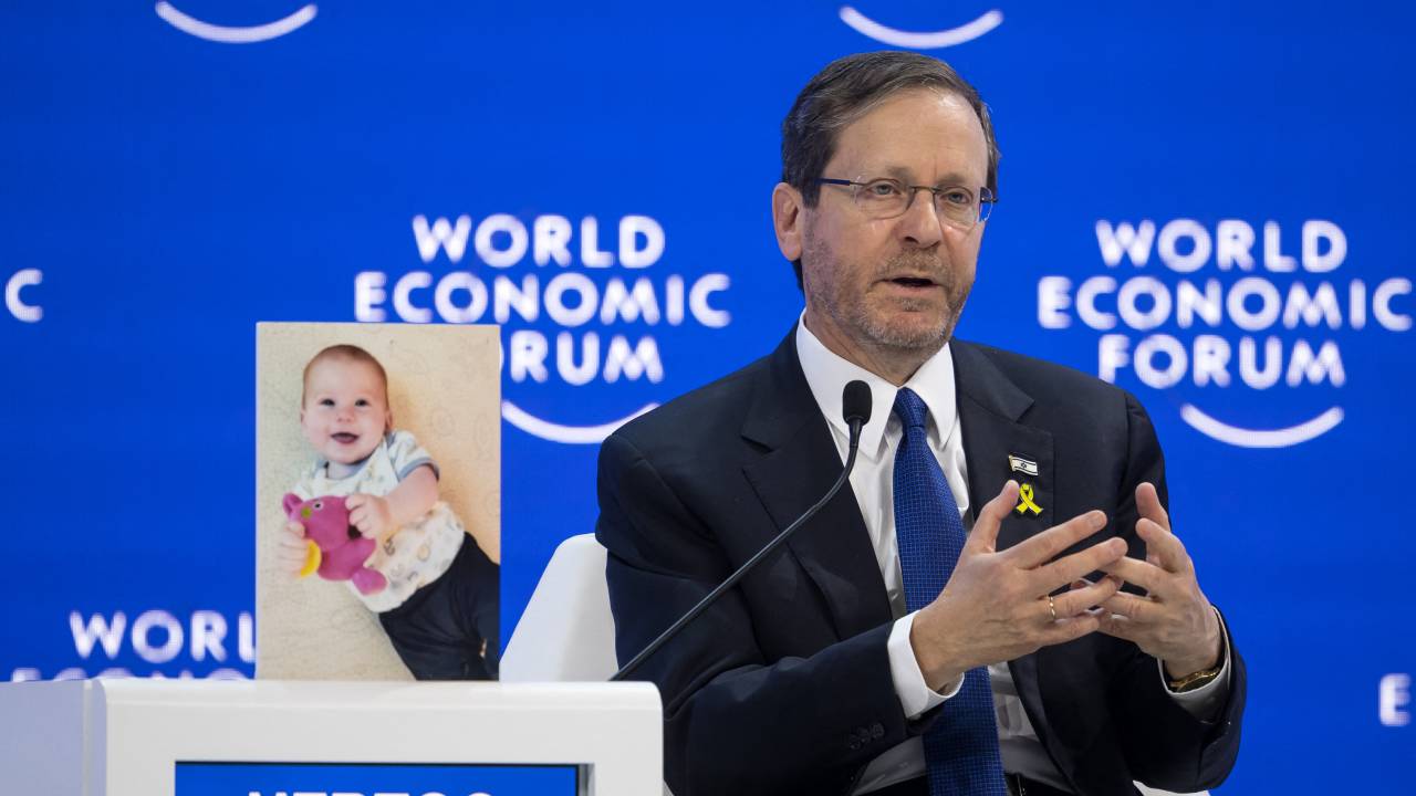 O presidente israelense, Isaac Herzog, discursa ao lado de uma fotografia do bebê Kfir Bibas, de 10 meses, mantido refém pelo Hamas, no Fórum Econômico Mundial (WEF), em Davos. 18/01/2024