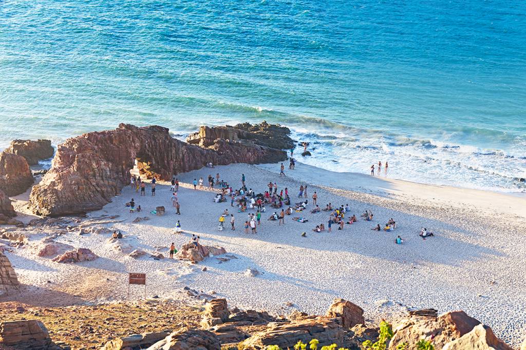 Elevated view of crowd of people on beach by rock formations, Jericoacoara national park, Ceara, Brazil, South America Elevated view of crowd of people on beach by rock formations, Jericoacoara national park, Ceara, Brazil, South America