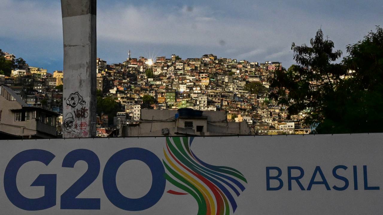 A G20 Brazil sign is set up in a brigde in front of Rocinha slum in Rio de Janeiro, Brazil, on February 15, 2024. On February 21 and 22, the first ministerial meeting of the Sherpa Track will be held in Rio de Janeiro. (Photo by Pablo PORCIUNCULA / AFP)