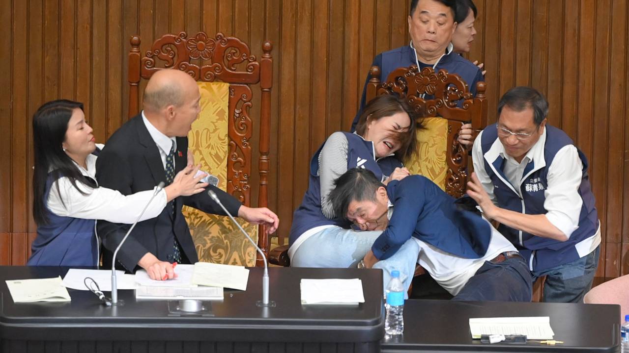 Taiwans ruling Democratic Progressive Party (DPP) lawmaker Chung Chia-pin (R in blue) grabs main opposition Kuomintang (KMT) Chen Ching-hui as Parliament Speaker Han Kuo-yu (2nd-L) looks on during the voting for the Parliament reform bill at Parliament in Taipei on May 17, 2024. (Photo by Sam Yeh / AFP)