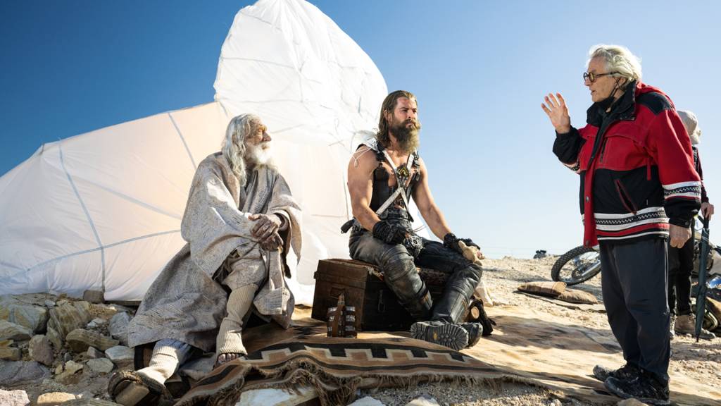 3-P-PING-DE-RODAPE-FILME—FURIOSA—bastidores-002.jpeg NO SET - Miller (à dir.) e Hemsworth: mudança de protagonismo