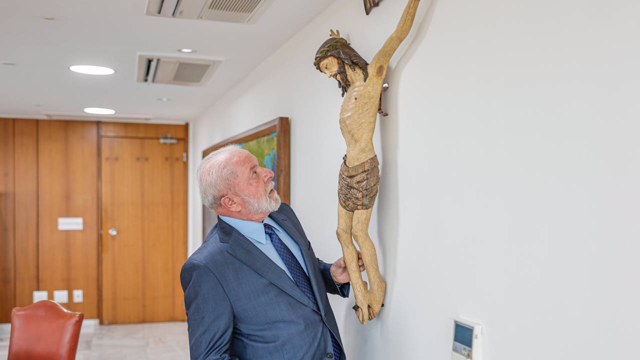 O presidente Luiz Inácio Lula da Silva observa imagem de Jesus Cristo crucificado no seu gabinete no Palácio do Planalto, em julho do ano passado