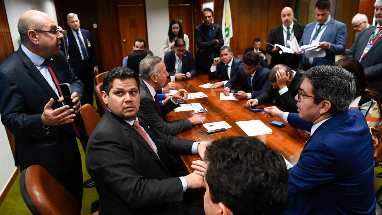 Davi Alcolumbre (sentado, à esq.) negocia acordo para análise de vetos em reunião com lideranças do Congresso