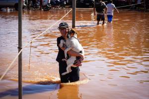 Um morador carrega um cachorro nas enchentes após fortes chuvas em Porto Alegre, Rio Grande do Sul, Brasil, na segunda-feira, 6 de maio de 2024 Um morador carrega um cachorro nas enchentes após fortes chuvas em Porto Alegre, Rio Grande do Sul, Brasil, na segunda-feira, 6 de maio de 2024