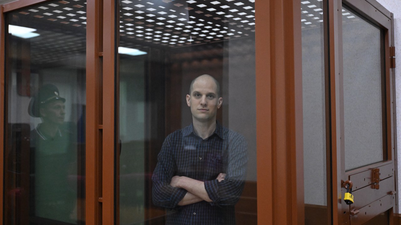 US journalist Evan Gershkovich, accused of espionage, looks out from inside a glass defendants' cage prior to a hearing in Yekaterinburg's Sverdlovsk Regional Court on June 26, 2024. (Photo by NATALIA KOLESNIKOVA / AFP)