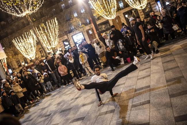 New Year preparations in Paris PARIS, FRANCE - DECEMBER 25: A breakdancer performs a street show at the Champs-Elysees as the people celebrate Christmas ahead of the New Year's eve in Paris, France on December 25, 2023. (Photo by Bruno Thevenin/Anadolu via Getty Images)