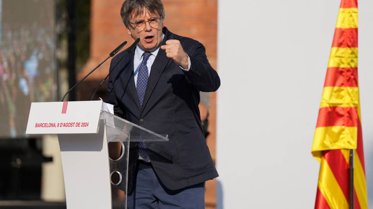 Catalonia's exiled separatist leader Carles Puigdemont depivers a speech on stage as his hardline separatist JxCAT party has scheduled a welcome ceremony, ahead of an investiture vote at the Parliament of Catalonia, in Barcelona on August 8, 2024. Catalonia's parliament is set to elect a new leader for the Spanish region, but the planned return of exiled separatist leader Carles Puigdemont even though he faces arrest threatens to derail the event. After months of negotiations following an inconclusive May regional election, the leader of the local branch of Spain's ruling Socialists Salvador Illa is poised to become Catalonia's new leader. But the vote could be upended if Puigdemont -- who fled to Belgium shortly after Catalonia's failed 2017 independence bid to avoid prosecution -- returns to Spain and is arrested. (Photo by Cesar Manso / AFP)