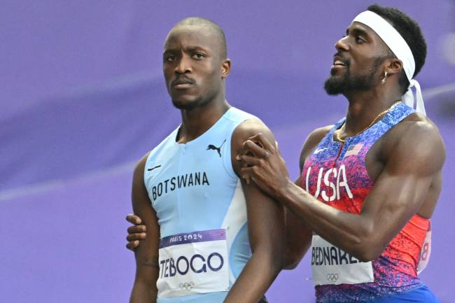 Silver medallist US' Kenneth Bednarek (R) congratulates Gold medallist Botswana's Letsile Tebogo after competing in the men's 200m final of the athletics event at the Paris 2024 Olympic Games at Stade de France in Saint-Denis, north of Paris, on August 8, 2024. (Photo by Andrej ISAKOVIC / AFP)