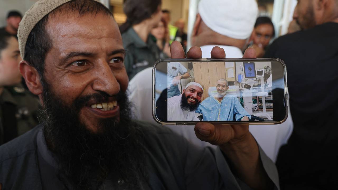 The brother of freed Israeli hostage Kaid Alkadi shows a picture with him on his phone after meeting him at Soroka Medical Center in Beersheva in southern Israel on August 27, 2024. The Israeli military said its forces rescued an Israeli hostage in southern Gaza on August 27 after a "complex operation" as the war between Israel and Hamas, now in its 11th month, showed no signs of abating. (Photo by Menahem KAHANA / AFP)