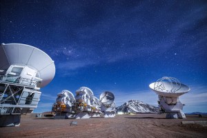 A beautiful view of the ALMA antennas working during the night, with the snowy Chajnantor mountain in the background. Credit: Alex Pérez