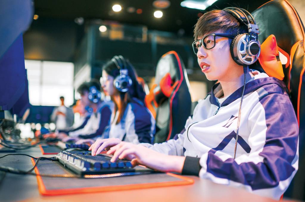 Asian Esports Team Gamer focus playing RPG First shooter Game in grand final sport event Championship Arena. Cyber Games Tournament Event NO COMANDO - Jovem chinês: o país tem 700 milhões de potenciais clientes