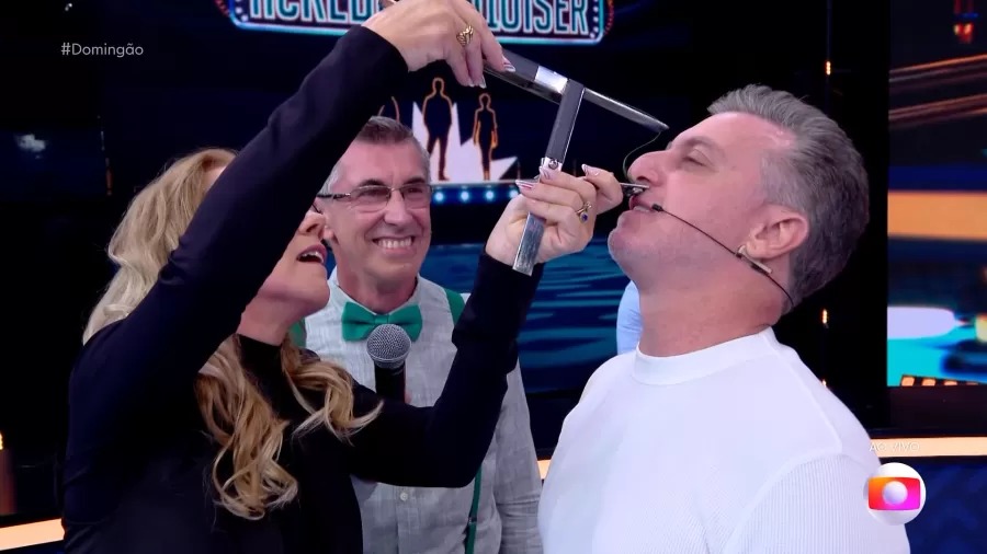 Luciano Huck flerta com a ‘bizarrice’ ao medir nariz ao vivo
