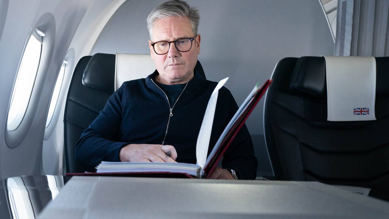Britain's Prime Minister Keir Starmer poses for a photograph as he works whilst travelling on a Government aeroplane on November 17, 2024, en route to attend the G20 summit in Rio de Janeiro, Brazil. The G20 Leaders' Summit will take place in Rio de Janeiro between November 18 and 19, 2024. (Photo by Stefan Rousseau / POOL / AFP)