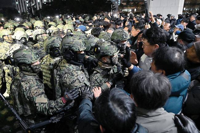 SKOREA-POLITICS-CONFLICT Alertados, deputados correram para o plenário, onde entraram empurrando e desafiando os soldados postados na entrada