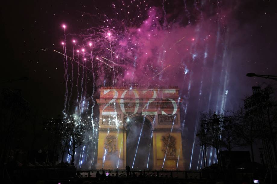Fogos de artifício iluminam o céu ao redor do Arco do Triunfo, na Avenida Champs-Élysées, em Paris, para celebrar a chegada de 2025