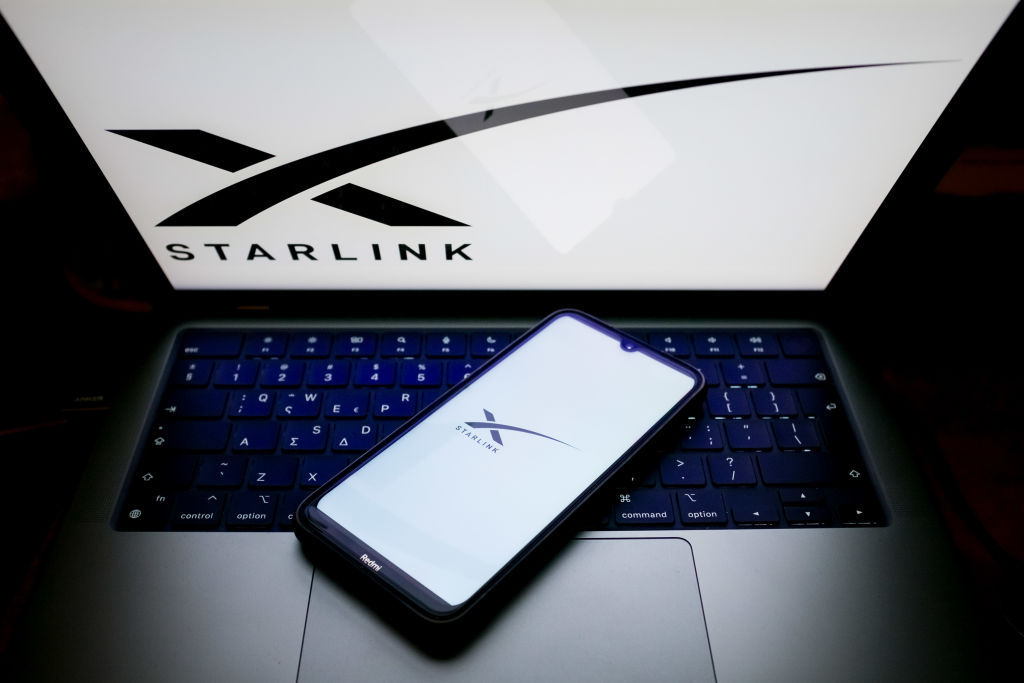 O logotipo da Starlink está sendo exibido na tela de um smartphone e na tela de um computador em Atenas, Grécia, em 24 de maio de 2024. (Foto de Nikolas Kokovlis/NurPhoto via Getty Images)