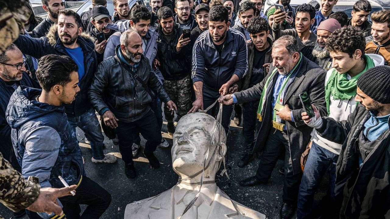 NO CHÃO - Damasco: moradores botam abaixo a estátua de Hafez al-Assad, o fundador do clã