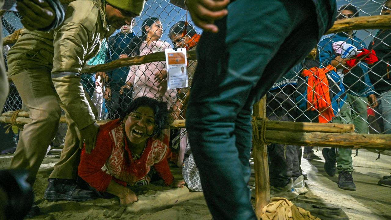 Mulher tenta escapar de debandada durante a peregrinação hindu de Kumbh Mela, na Índia. 29/01/2025