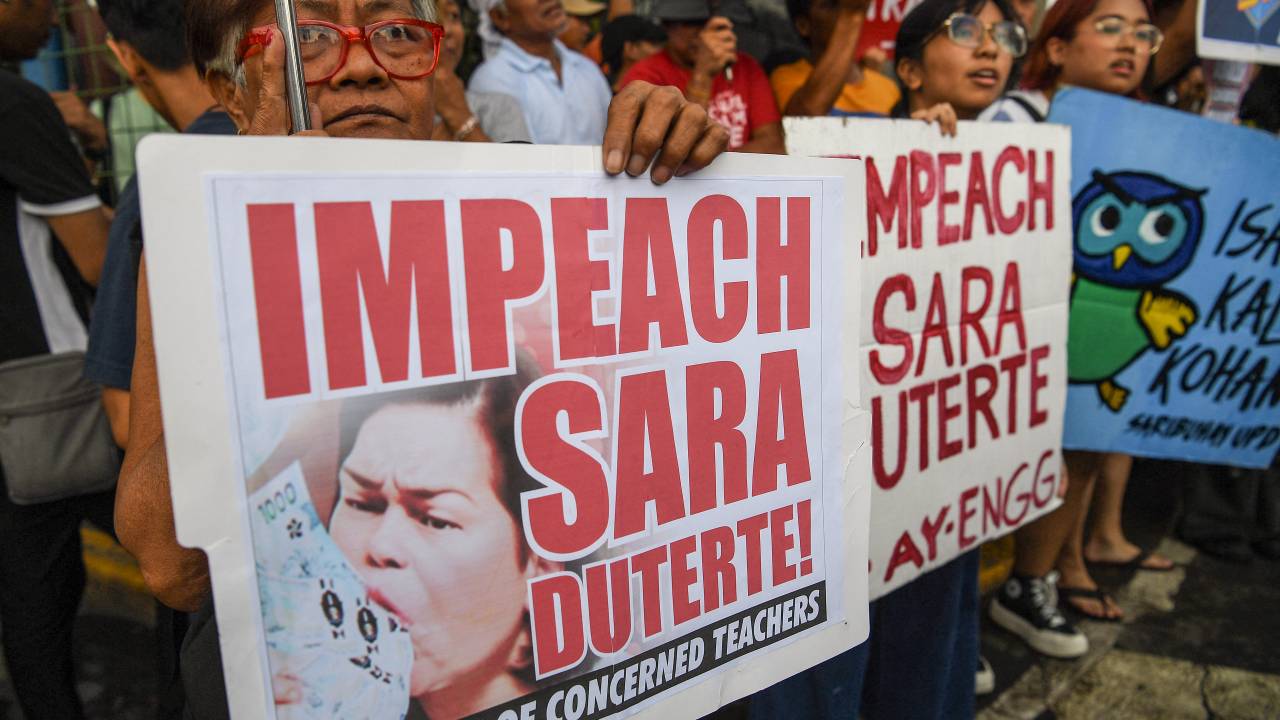 (FILES) Protesters hold placards during a rally in front of the Congress building in Manila on December 4, 2024, to coincide with the filing of an impeachment complaint against Philippine Vice President Sara Duterte. Philippine lawmakers on February 5 voted to send articles of impeachment against Vice President Sara Duterte to the Senate, a day before the current congressional session was set to end. (Photo by TED ALJIBE / AFP)
