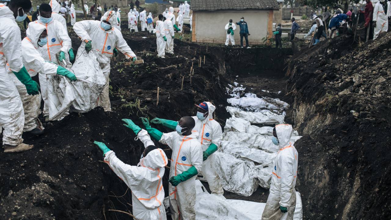 Membros da Cruz Vermelha Congolesa e da Proteção Civil descarregam os corpos das vítimas dos recentes confrontos em Goma para sepultamento