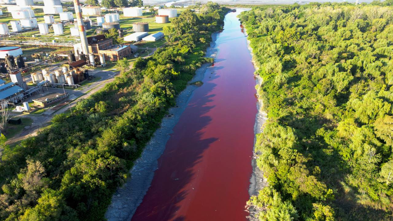 Rio Sarandí, em subúrbio da capital argentina, Buenos Aires, fica vermelho vivo. 06/02/2025