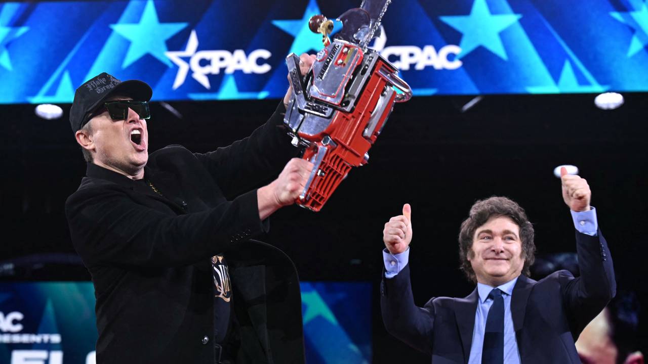 Elon Musk (L) holds a chainsaw alongside Argentine President Javier Milei during the annual Conservative Political Action Conference (CPAC) at the Gaylord National Resort & Convention Center at National Harbor in Oxon Hill, Maryland, on February 20, 2025. The chainsaw was a present to Elon Musk from Argentina's President Javier Milei. (Photo by SAUL LOEB / AFP)