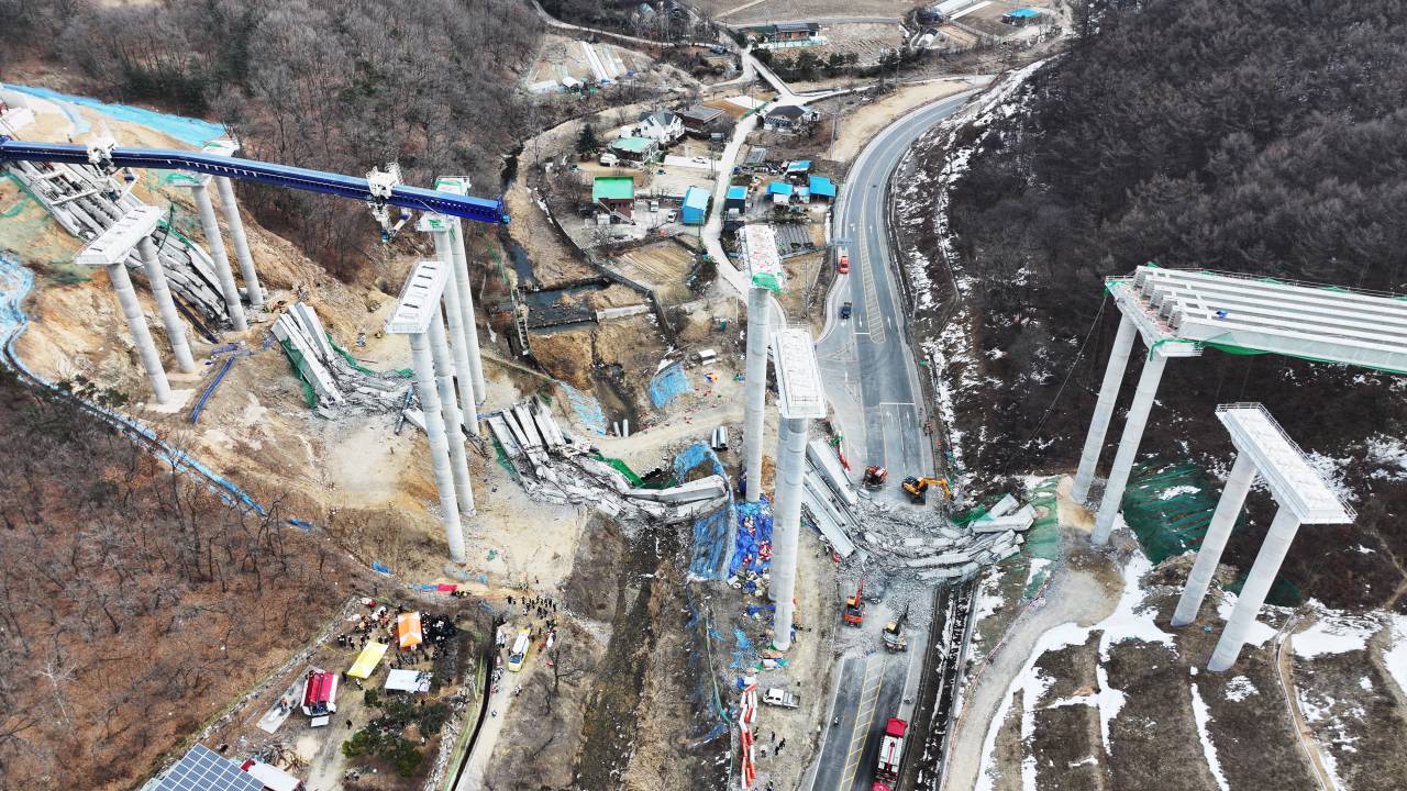 Rescue members search for missing workers after a bridge collapsed at an expressway construction site in Anseong on February 25, 2025. Two people were killed and seven injured after a bridge collapsed at an expressway construction site in South Korea on February 25, authorities said. (Photo by YONHAP / AFP) / - South Korea OUT / NO ARCHIVES - RESTRICTED TO SUBSCRIPTION USE