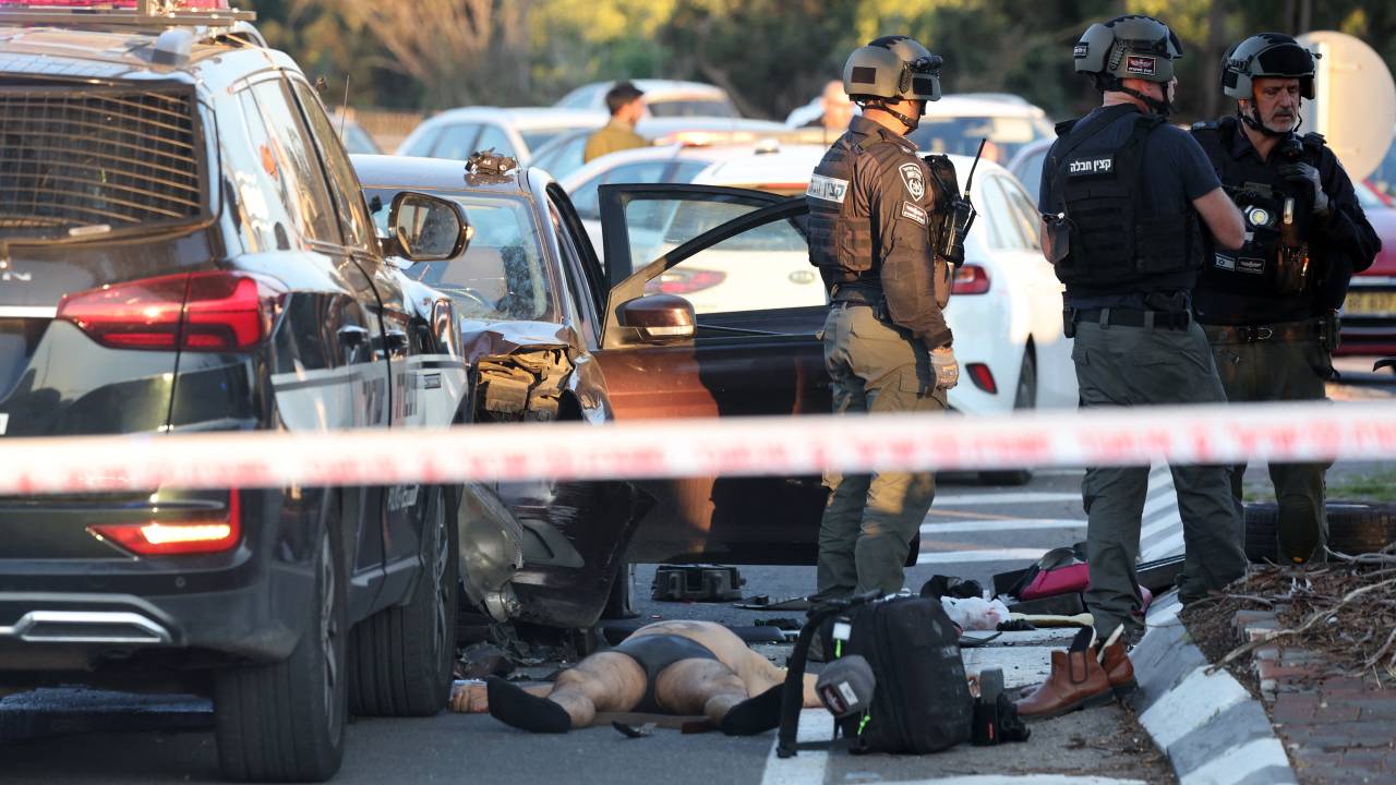 EDITORS NOTE: Graphic content / The body of a man lies next to a damaged vehicle that reportedly rammed into pedestrians at the Karkur junction south of the city of Haifa in northern Israel on February 27, 2025. Israel's first responders, Magen David Adom, said their team was treating seven casualties at the site of the incident, including one in serious condition. (Photo by Jack GUEZ / AFP)