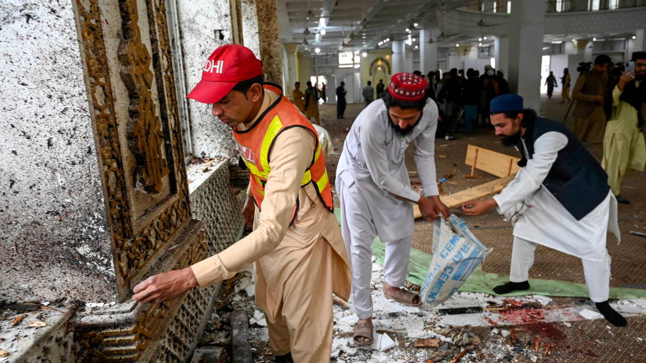 A rescuer collects remnants after a suicide blast amid friday prayers at Dar-ul-Uloom Haqqania school in Akora Khattak, east of Peshawar on February 28, 2025. A suicide attack at an Islamic religious school in Pakistan known as the "University of Jihad" -- where key Taliban leaders have studied -- killed four people on February 28, police said. (Photo by Abdul MAJEED / AFP)