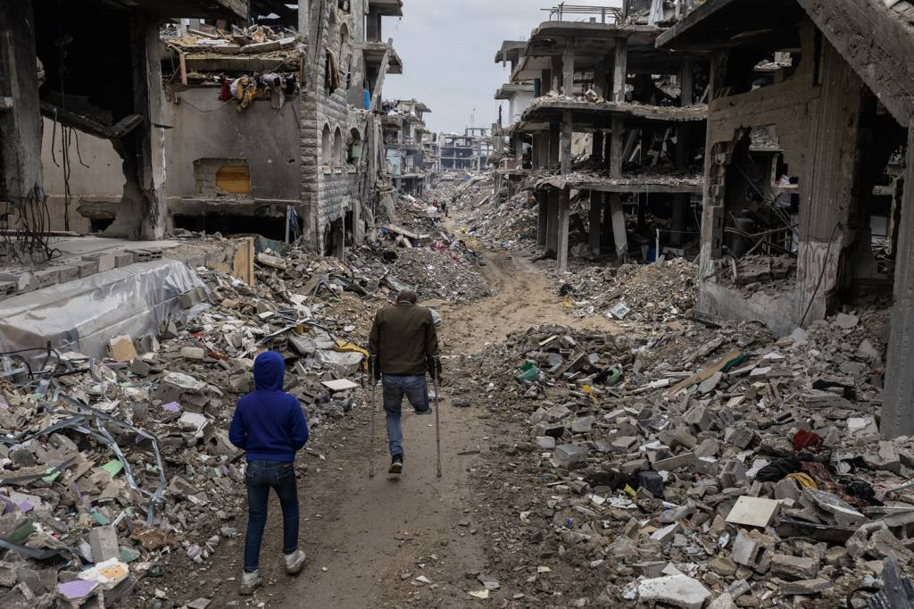 GettyImages-2201278468.jpg DESTRUIÇÃO - Palestinos em cidade bombardeada: 50 bilhões de dólares e quinze anos para remover escombros