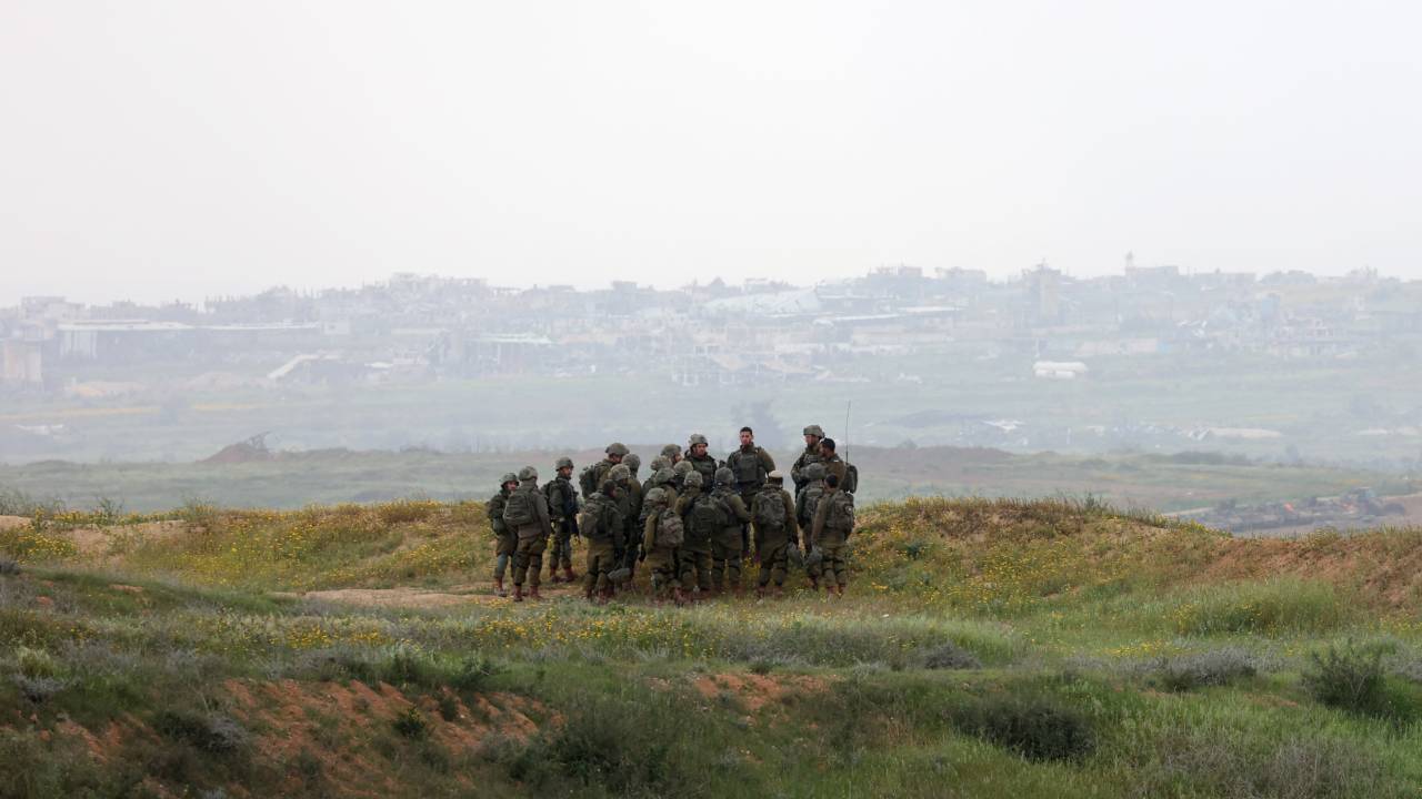 Israeli army soldiers stand in a position along Israel's southern border with the northern Gaza Strip on March 20, 2025. Israel bombarded Gaza and pressed its ground operations on March 20, after issuing what it called a "last warning" for Palestinians to return hostages and remove Hamas from power. (Photo by GIL COHEN-MAGEN / AFP)