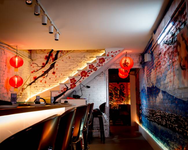 Balcão do Omakase Nihon. Cada é decorada com grafites com temas japoneses