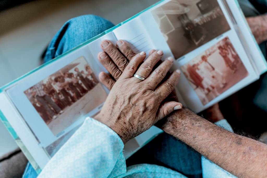 Close-up of couple hands on top of a photo album PAZ DE ESPÍRITO - O que superidosos têm em comum: segundo estudo da USP, muita tranquilidade e pouco rancor