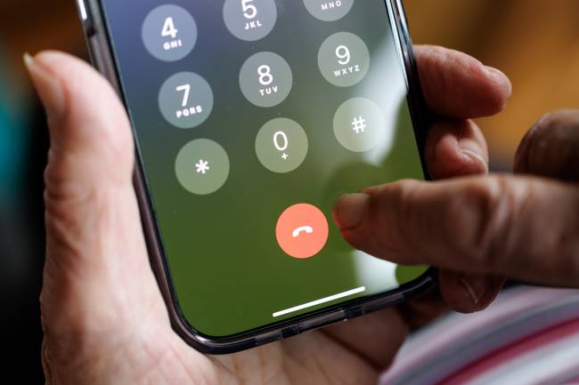 Elderly lady on the phone with a smartphone 16 March 2025, Lower Saxony, Norden: A woman over 90 years old makes a phone call with an iphone on 16.03.2025 in Norden (Lower Saxony).
