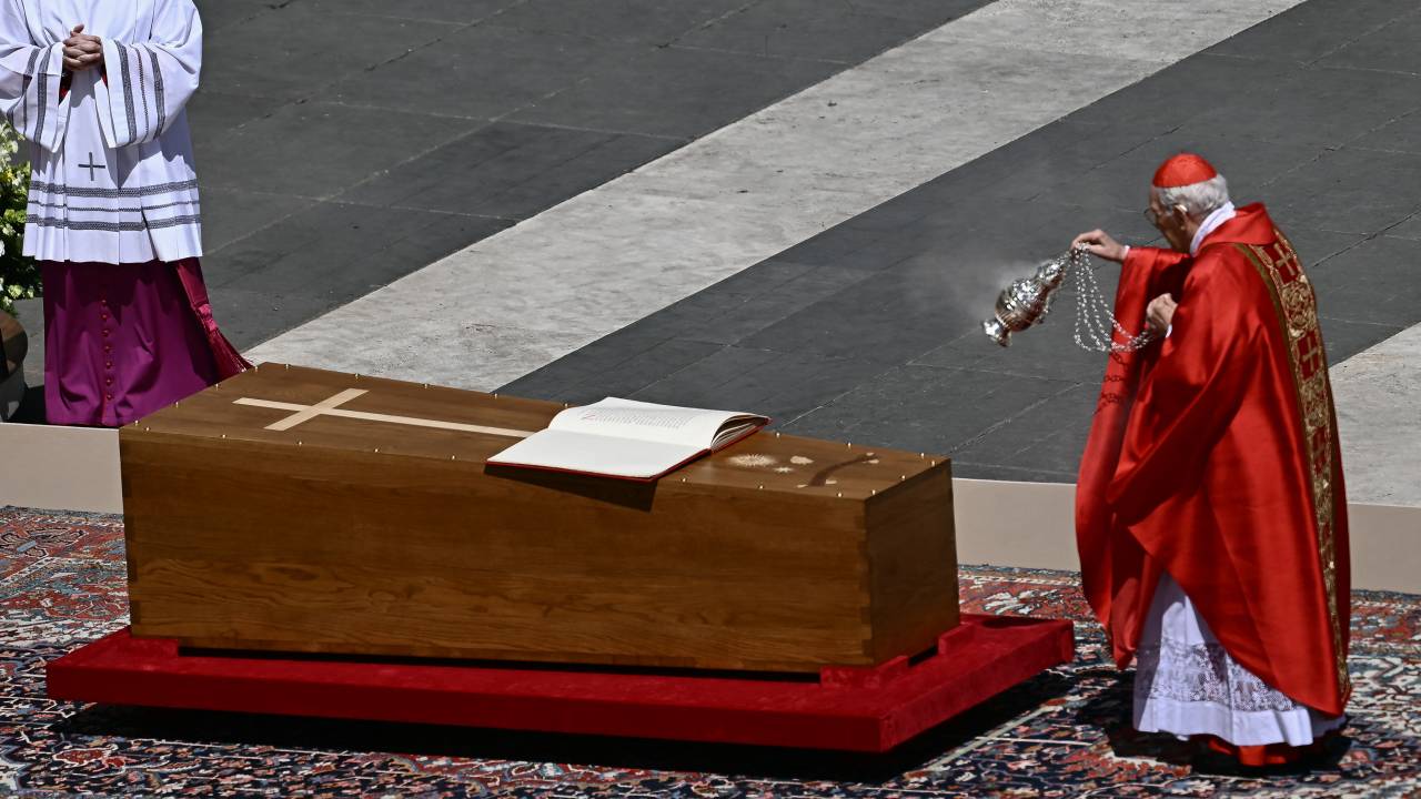 Italian cardinal Giovanni Battista Re swings an incense burner towards the coffin of late Pope Francis with the book of the gospels displayed on it during the funeral ceremony at St Peter's Square in The Vatican on April 26, 2025. (Photo by Filippo MONTEFORTE / AFP)
