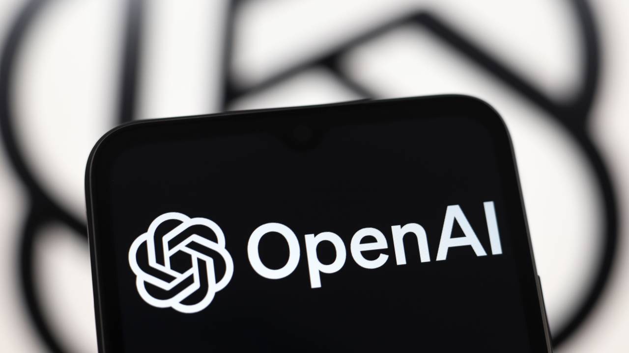 The OpenAI logo appears on a smartphone screen and in the background on a computer screen in Reno, United States, on November 21, 2024.