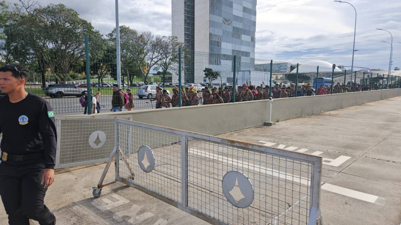 Indígenas caminham pela calçada do Palácio do Planalto, em Brasília